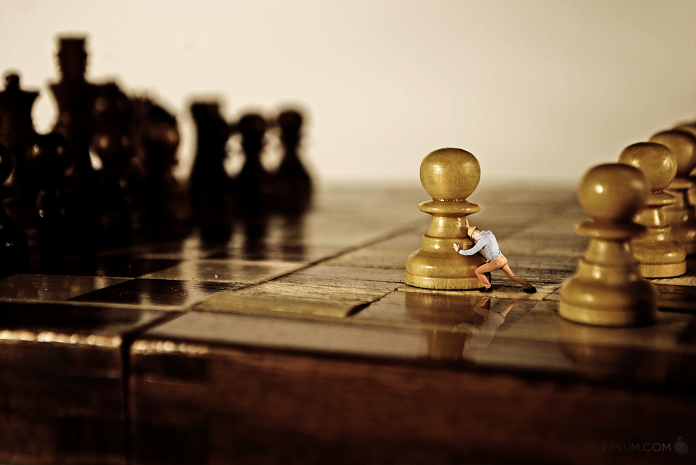 The-journey-of-a-thousand-miles-begins-with-a-single-step. Man-pushing-a-chess-figure-The-journey-of-a-thousand-miles-begins-with-a-single-step.