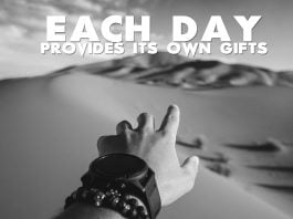 Each-day-provides-its-own-gifts-inspirational-quote-mans-hand-desert-sand